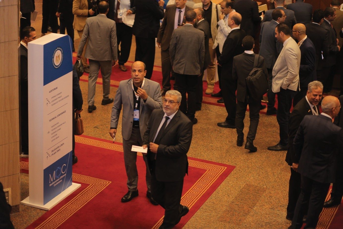 Delegates between sessions beside an MOC wayfinding totem